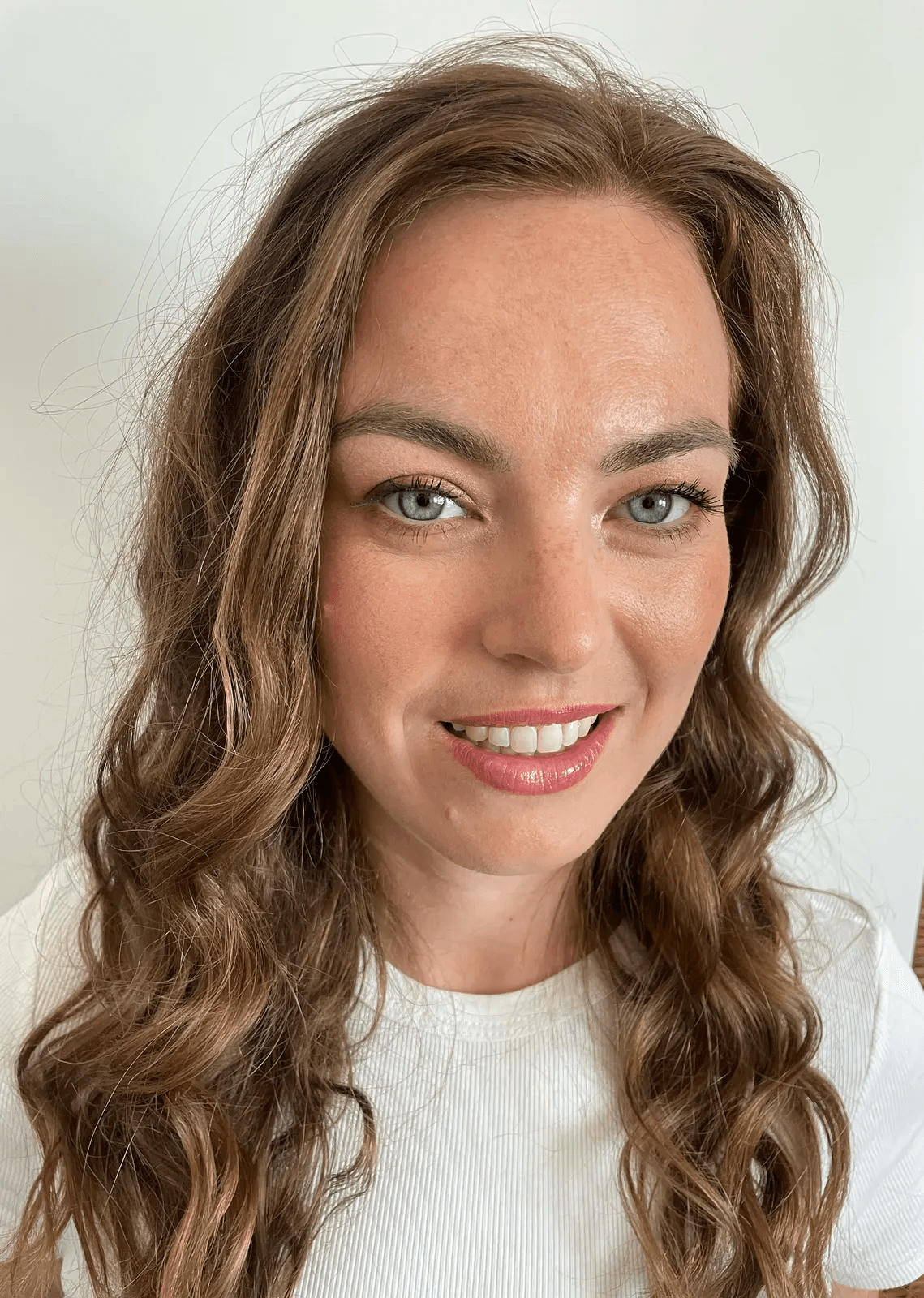 Denní make-up s jemnými vlnami v dlouhých hnědých vlasech